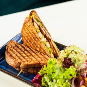 Delicious grilled chicken sandwich served with mixed green salad and fries.